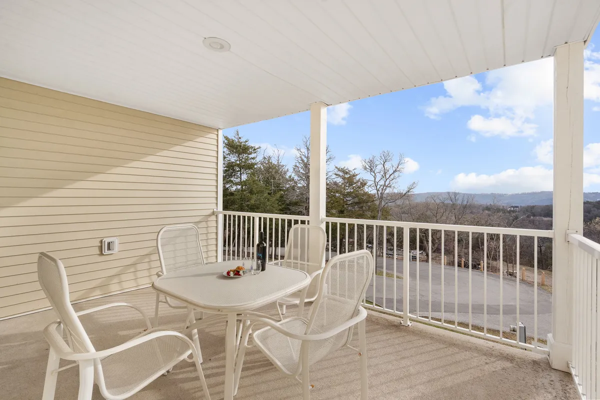 A tranquil deck scene with a patio table and chairs overlooking a peaceful landscape, ideal for outdoor dining, morning coffee, or evening relaxation. The view invites guests to step outside and embrace the natural setting.