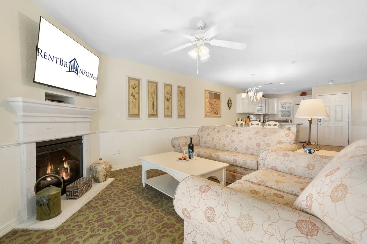 A cozy interior view of a living area with a fireplace, comfortable sofa, coffee table, and TV. The atmosphere is warm and inviting, ideal for relaxing after a day of outdoor exploration with your pet.