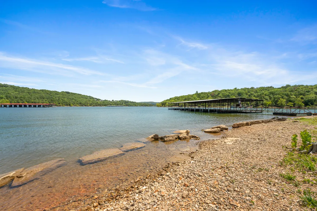 A tranquil lake with a boathouse set against rolling green hills. The peaceful waters and natural surroundings highlight opportunities for fishing, boating, and enjoying sunsets—all activities that encourage guests to embrace the outdoors and disconnect from technology.