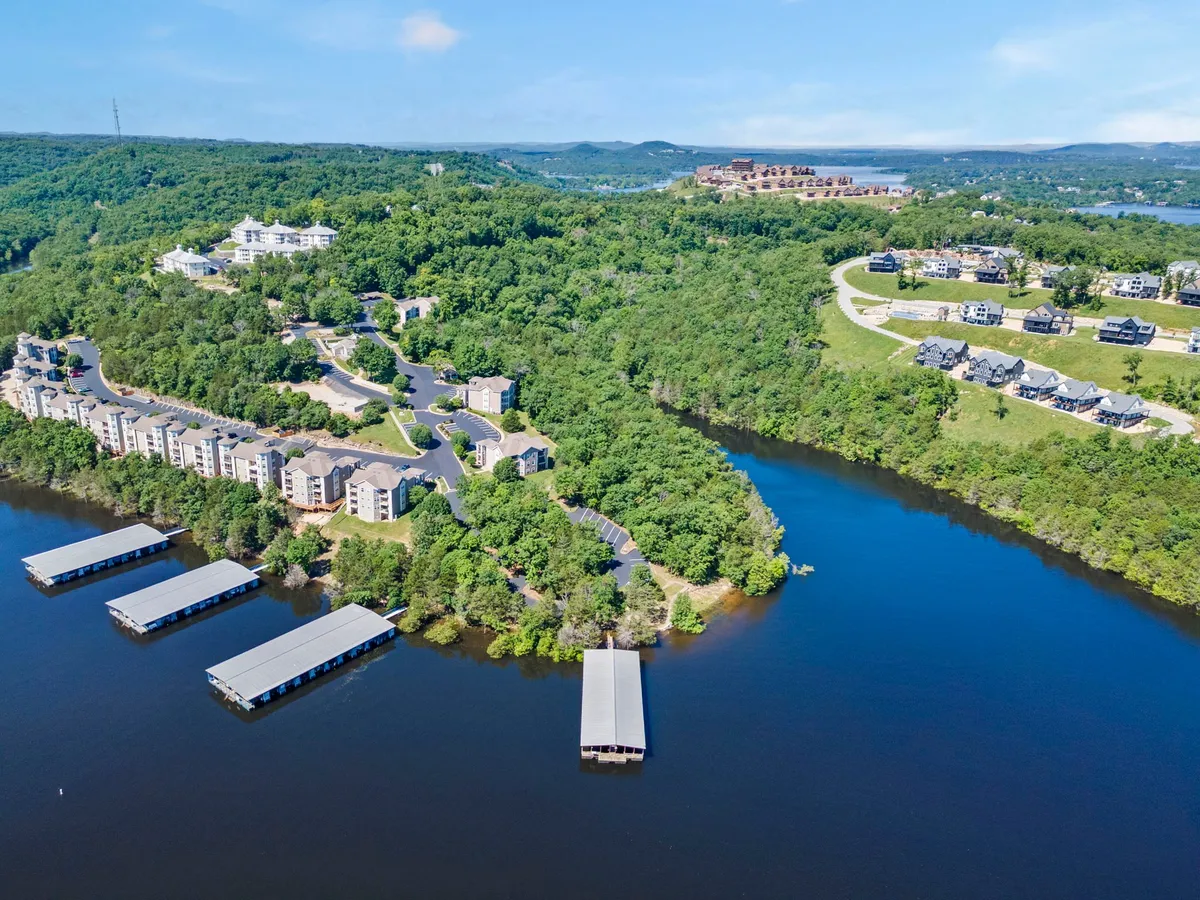 An exterior scene featuring waterfront properties, marinas, rolling green hills, and roadways that wind through the landscape. The peaceful setting is ideal for outdoor activities such as hiking, boating, and relaxed strolls by the water's edge.