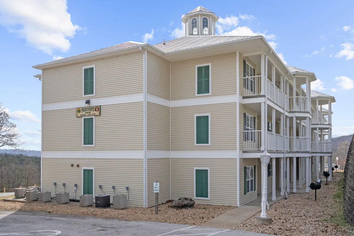 The building’s exterior facade, featuring charming balconies and a distinctive cupola. The balconies invite images of guests enjoying quiet moments or scenic views, offering a glimpse into private yet connected vacation living.
